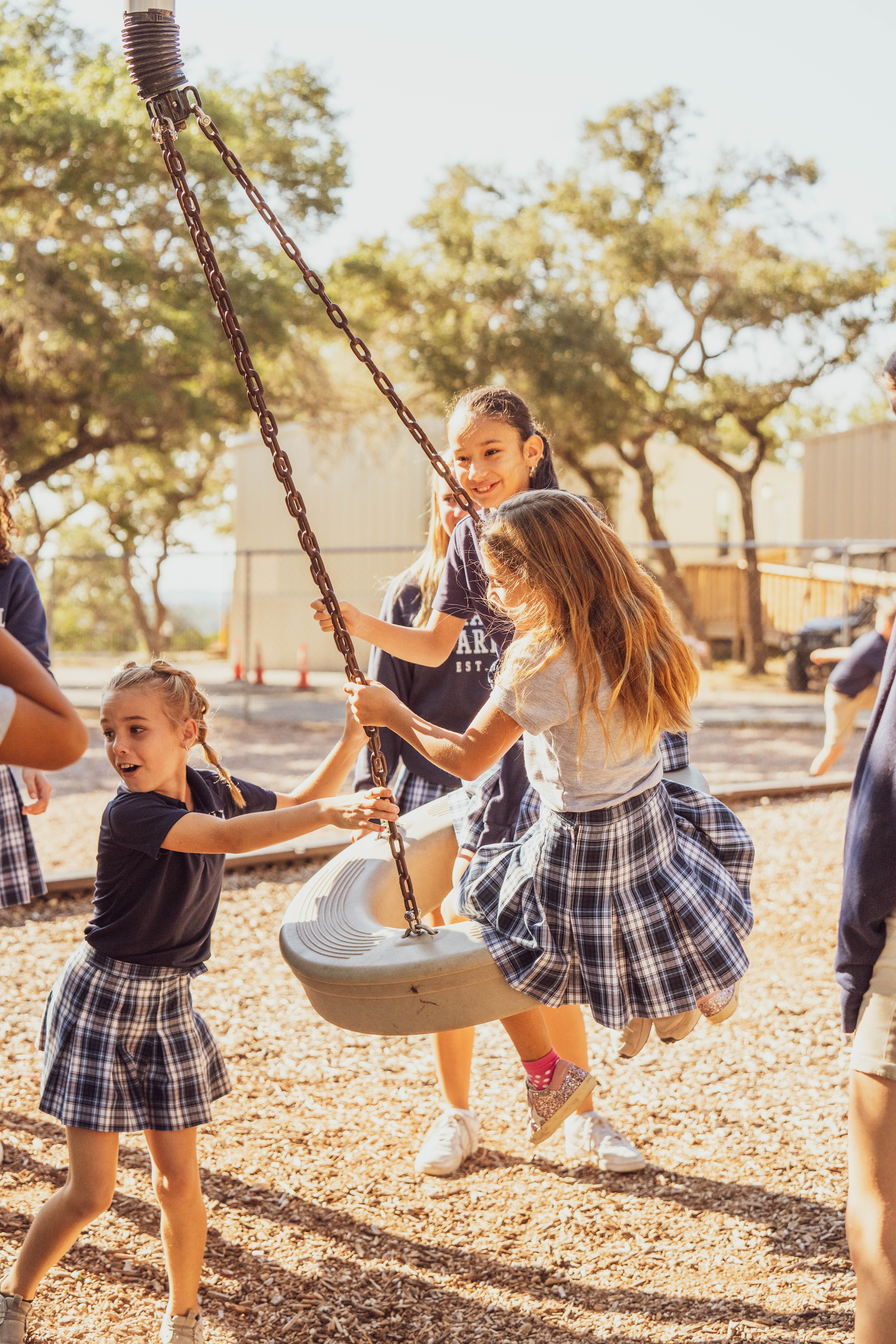 elementary students swinging on playgrounf